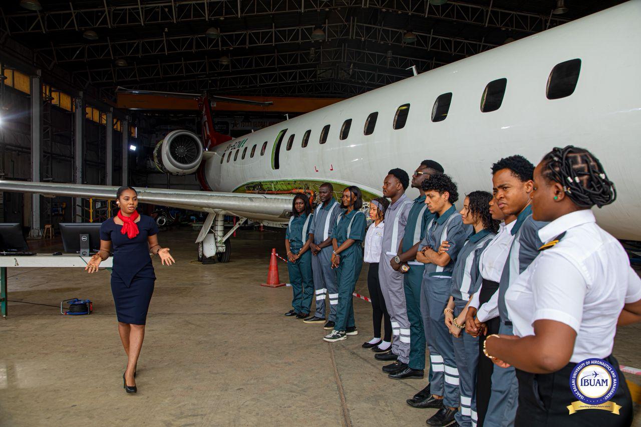 IBUAM student engineers and student pilots with instructor in front of jet in 7Star Hangar